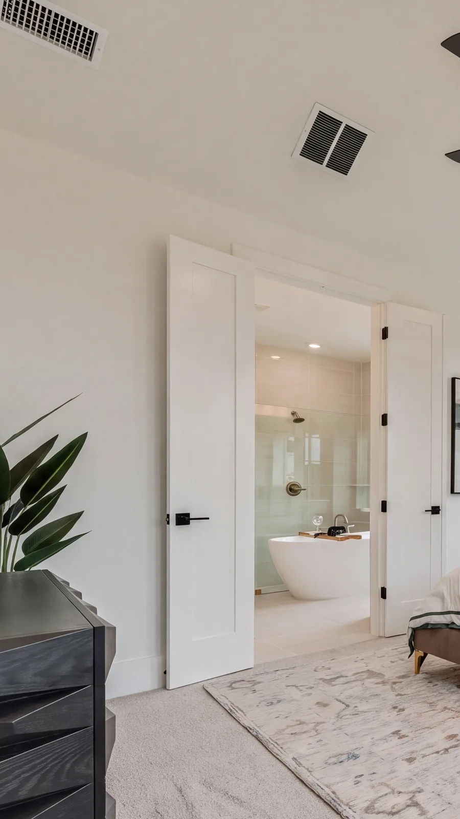 Primary suite at 821 Oleander, wide frame and its freestanding tub through the double doors